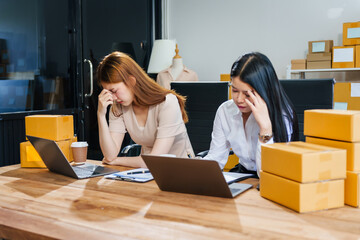 Two young female entrepreneurs face stress as their small business struggles. parcel boxes, sales...
