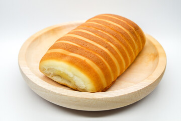 Bread rolls on wooden plate isolated on white background