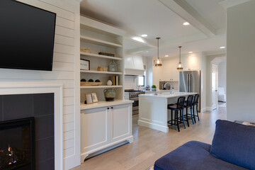 Bright white kitchen with island and three chairs, bathed in warm light, inviting for gatherings...