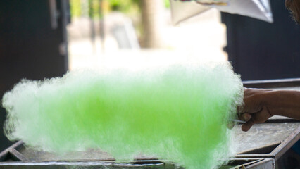 The seller is making gula kapas. Gula kapas is made from granulated sugar. Gula means sugar and...