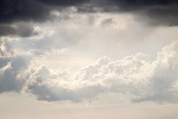 Dramatic clouds with light breaking through, offering hope amid dark skies.