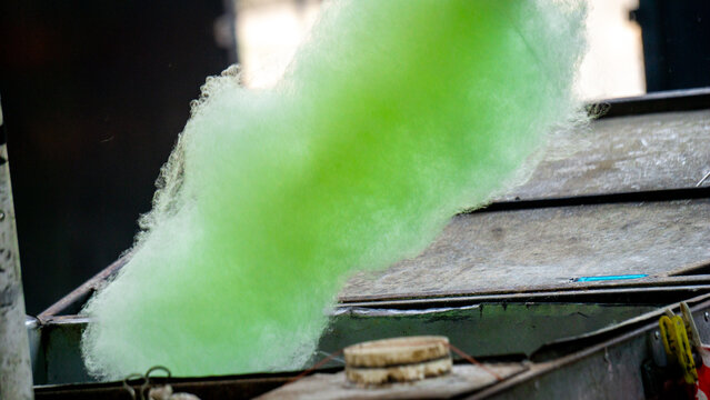 The seller is making gula kapas. Gula kapas is made from granulated sugar. Gula means sugar and kapas means cotton.