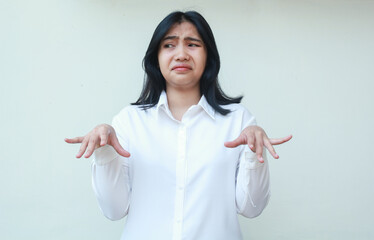 portrait of doubtful asian woman office girl wearing white formal suit shirt raising palms standing do uderestimate gesture showing do not believe expression looking away