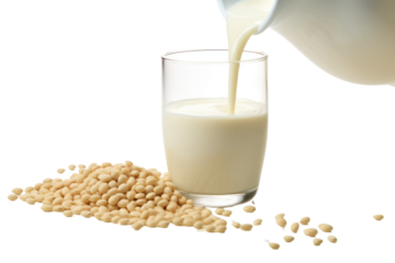 Close-up of soy milk pouring into a glass with soybeans in the background isolated on white background