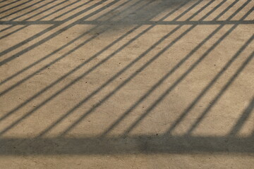 Line shadow of fence from sun rays reflect on concrete floor in the morning. Loft style. texture and surface background or backdrop. abstract pattern.
