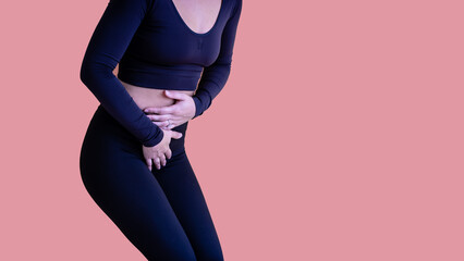 Female suffering from lower abdominal pain and is in distress and hunched over and holding her...