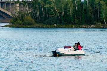 Two girls sailing on a catamaran on the river.