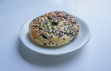 Delicious soft whole grain bread on a white plate on a white background.