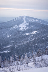 the top of a snowy mountain with a prepared slope for skiing