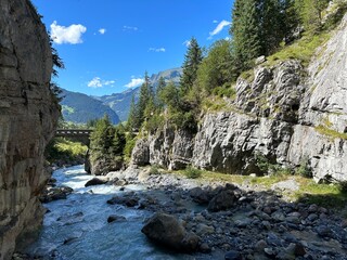 Glacial river running through rocky gorge at Glacier Canyon in Grindelwald, Switzerland taken on a sunny day