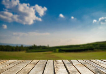 Wooden table top on blur mountain and grass field.Fresh and Relax concept.For montage product display or design key visual layout.View of copy space.