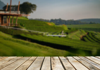 Wooden table top on blur green tea mountain and grass field.Fresh and Relax concept.For montage product display or design key visual layout.View of copy space.