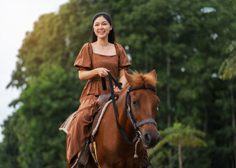 Obraz premium happy woman riding horse on meadow field