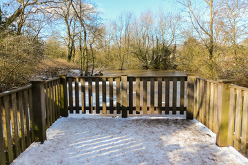Winter scene in a park in the UK, a frosty snowy start with blue skies.