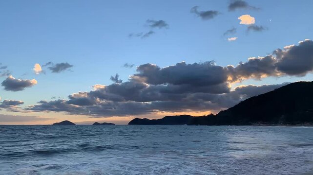 Time-lapse de um fim de tarde no mar.  O c&eacute;u com belas forma&ccedil;&otilde;es de nuvens e o mar azul. Ao fundo, duas ilhas bem famosas do litoral norte: Ilha das Couves e As Ilhas.
