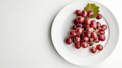 Bunch of red grapes in a plate with stems isolated on a white background.