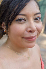 Naklejka premium Smiling Woman with Long Black Hair and Gold Necklace. Close up.
