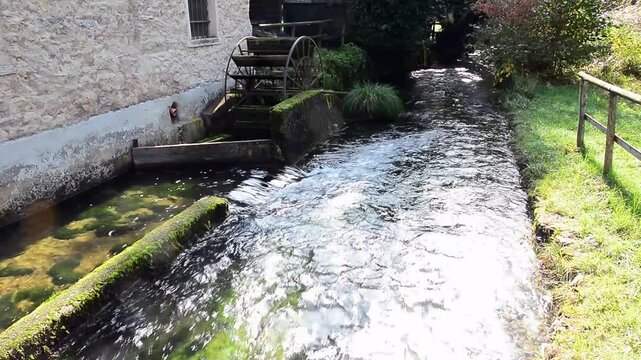 Water flows slowly near an old abandoned mill