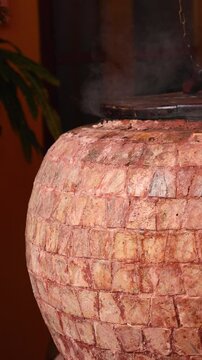 A stone brick tandoor oven in a luxurious restaurant for roasting meat and fish in the tandoori style.