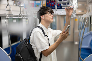 電車内でスマホを操作する男性