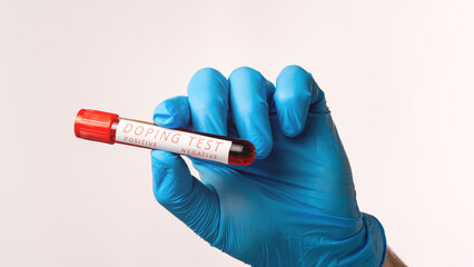 A person is holding a red tube with the word 