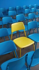Fototapeta premium Yellow chair is sitting in a row of blue chairs
