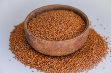Camelina sativa seeds, camelina seeds in wooden bowl isolated on white background. Raw material for camelina oil.