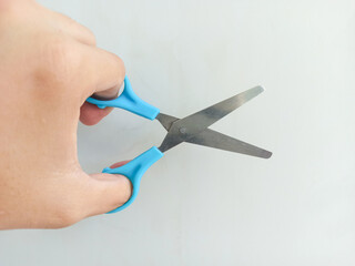 hand holding scissors on a white background. Close up.