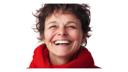 Joyful woman with curly hair wearing a bright red scarf smiles broadly against a neutral background in a candid moment of happiness.