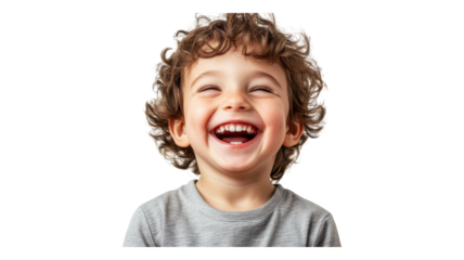 A joyful child with curly hair laughing happily in a light gray shirt against a plain background.