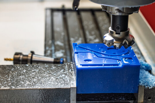 Milling tool works on a CNC milling machine. Metalworking CNC lathe milling machine with coolant. Milling  a piece of plastic. Industrial metalworking cutting process on cnc machine.