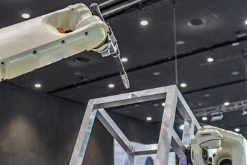 Robot welding steel. Industrial welding robot and working with metal parts. Robot welds steel. Welding head. Welding robot. CNC welding. Robotization and automation of the welding process.