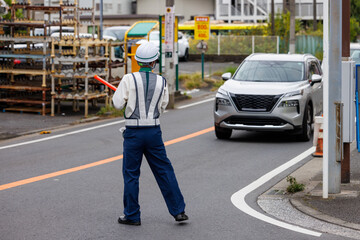 道路を走る自動車を誘導する交通誘導員