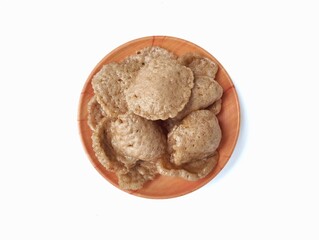 Kerupuk on plate isolated on white background. Kerupuk is Indonesian traditional food made of flour dough mixed with crushed shrimp or fish.