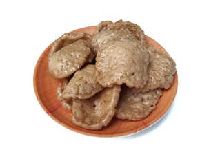 Kerupuk on plate isolated on white background. Kerupuk is Indonesian traditional food made of flour dough mixed with crushed shrimp or fish.