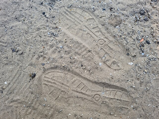 Sandal footprints on the ground behind the house in the afternoon
