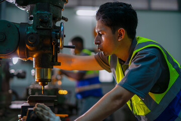 Blue collar workers upskill at lathe machine shop.