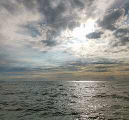 Obraz premium The sky is cloudy and the sun is shining through the clouds
