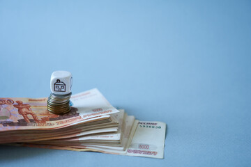 Rubles and coins on a blue background. The concept of preserving money and wealth.