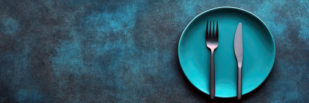 Conceptual image highlighting eating disorders and mental health awareness with empty plate and cutlery. Horizontal banner. Copy space. Struggle with eating disorders. Anorexia, bulimia problem