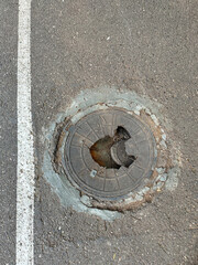 Broken manhole cover or inspection hatch. Cast-iron access cover with damage was repaired several...
