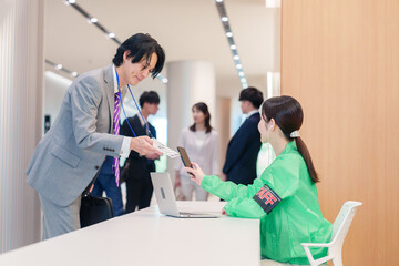 Fototapeta premium カンファレンスの受付スタッフと参加者