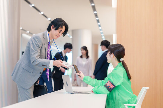 カンファレンスの受付スタッフと参加者