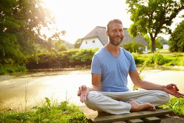 Lotus meditation, portrait and man outdoor with calm, relax and balance for mindfulness. Zen, nature and male person from Italy with padmasana pose for breathing, health and wellness outdoor.