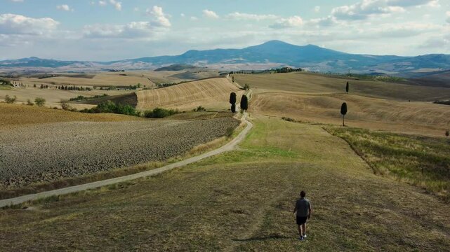 person walking in Tuscany-s countryside