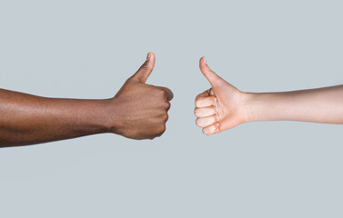 African man hand showing thumb up. Caucasian woman hands showing thumbs up. Black and white thumbs...