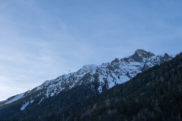 Snow covered mountains with paragliders in sky