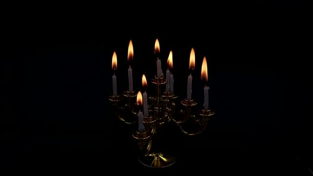 candle burn in a candlestick on isolated black