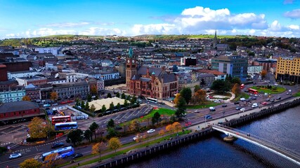 Obraz premium City of Derry aka Londonderry in Northern Ireland aerial view - A Dramatic Cityscape by the River Foyle Featuring a Beautiful Pedestrian Bridge