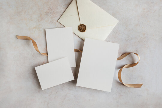 Blank invitation cards and envelope mockup set with gold ribbon and wax seal top view